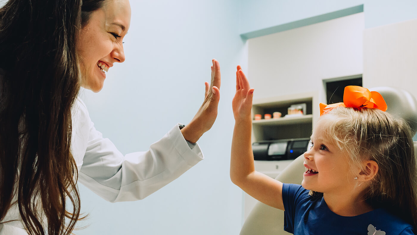 A CDP dentist high fives a pediatric patient after a great checkup.