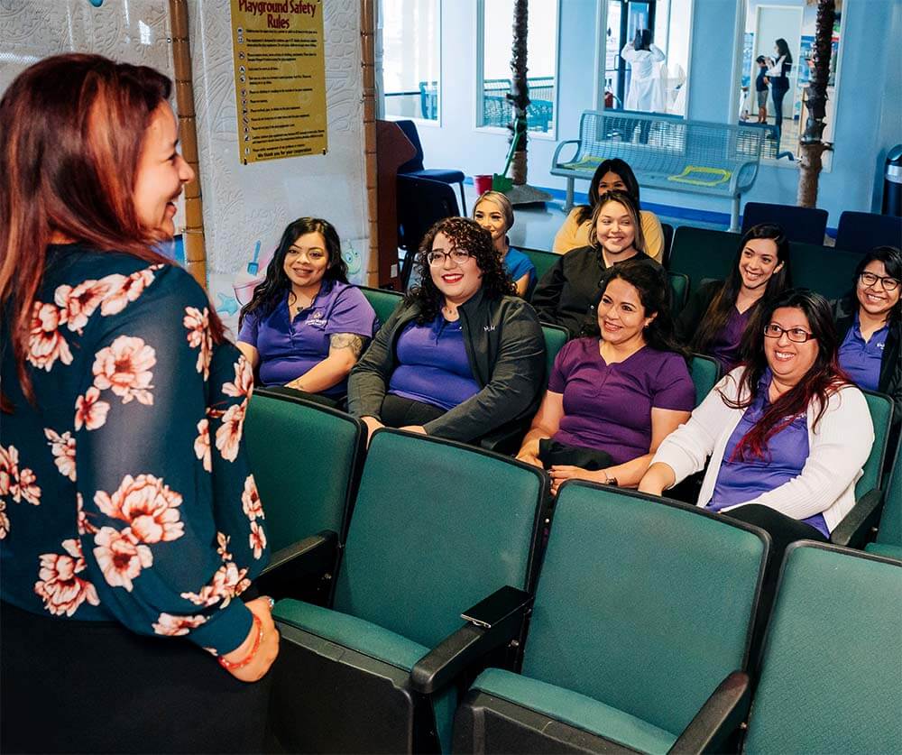 A practice leader meets with her team, fostering a positive dental office environment.