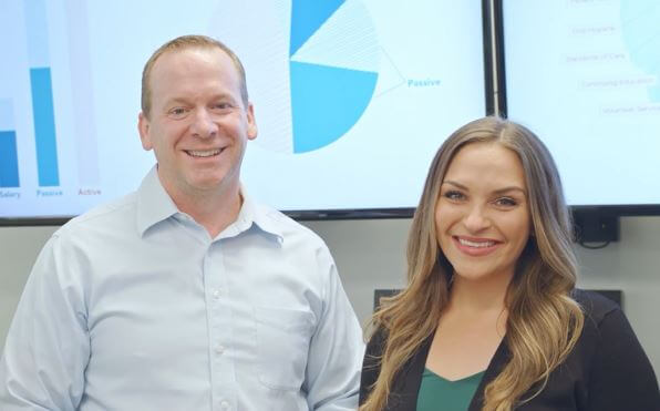 A dentist stands with a leader at her company, happy to have learned about her options to pay off her dental school debt.