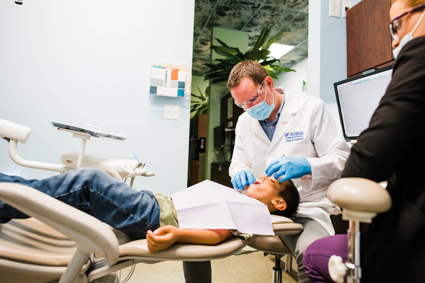 A dentist performs a routine dental cleaning on a pediatric patient.