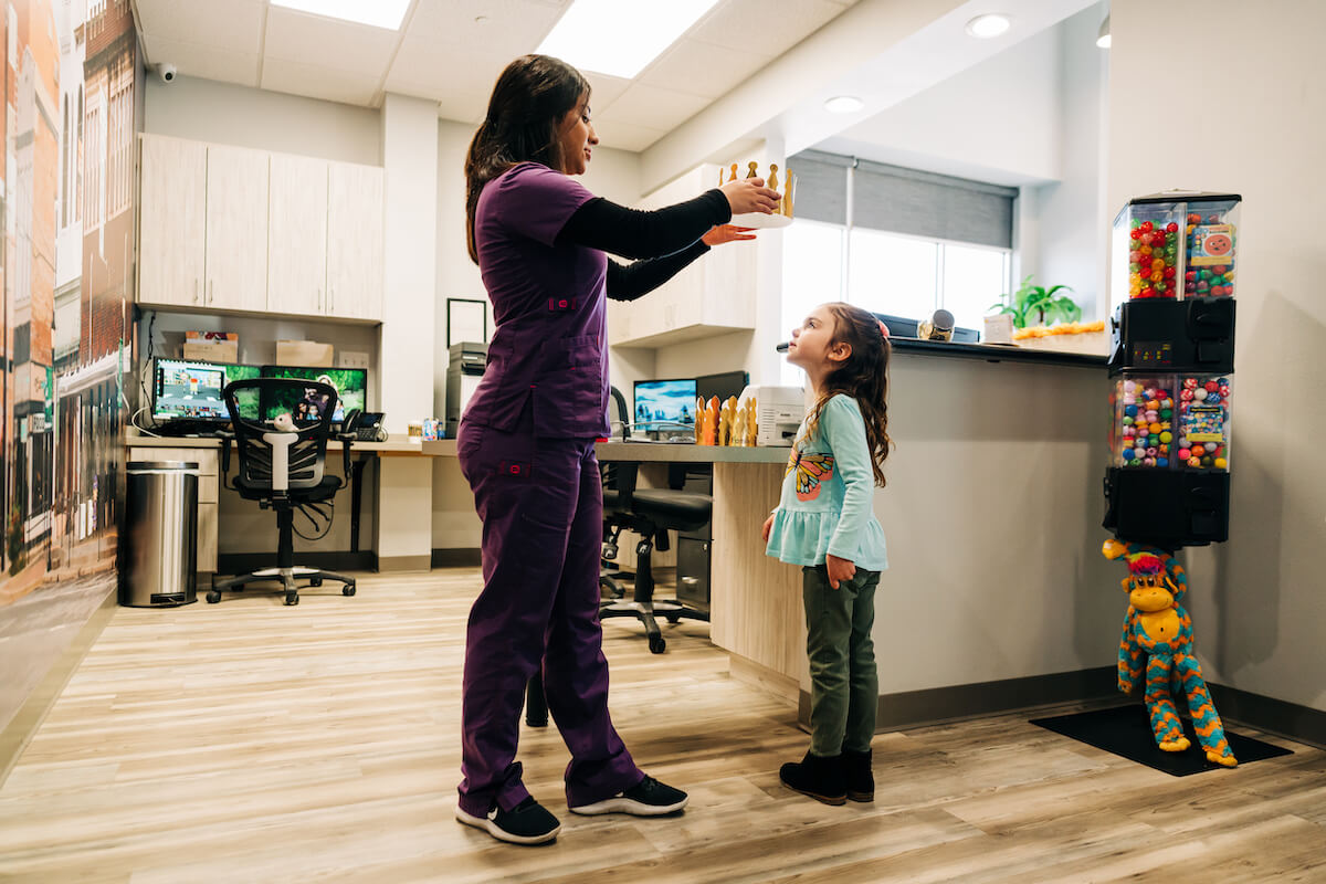 A dental hygienist places a crown on a pediatric patient at one of CDP's dental support organization-led practices.