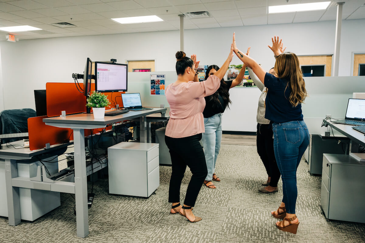 The support team in a dental service organization congratulates each other on another job well done.