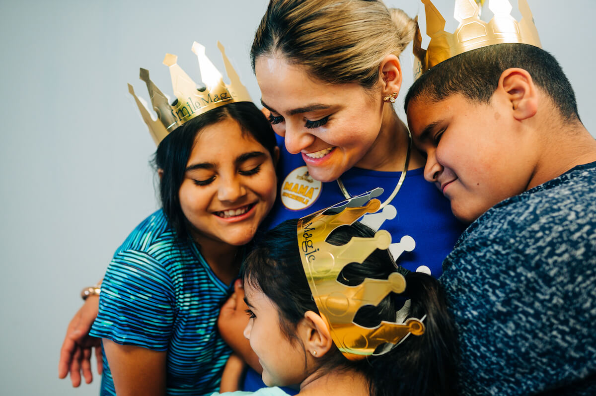 A mother hugs her children after their checkups at a dental service organization-owned practice.