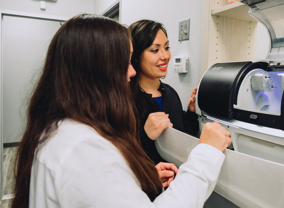 A new dentist learns how to work the equipment in her practice with her mentor. New dentists at Community Dental Partners benefit from the mentorship program.