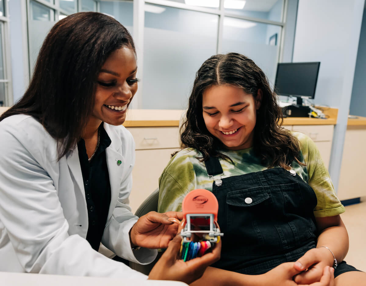 An orthodontist shows a patient her options for braces at her practice managed by a dental DSO company.