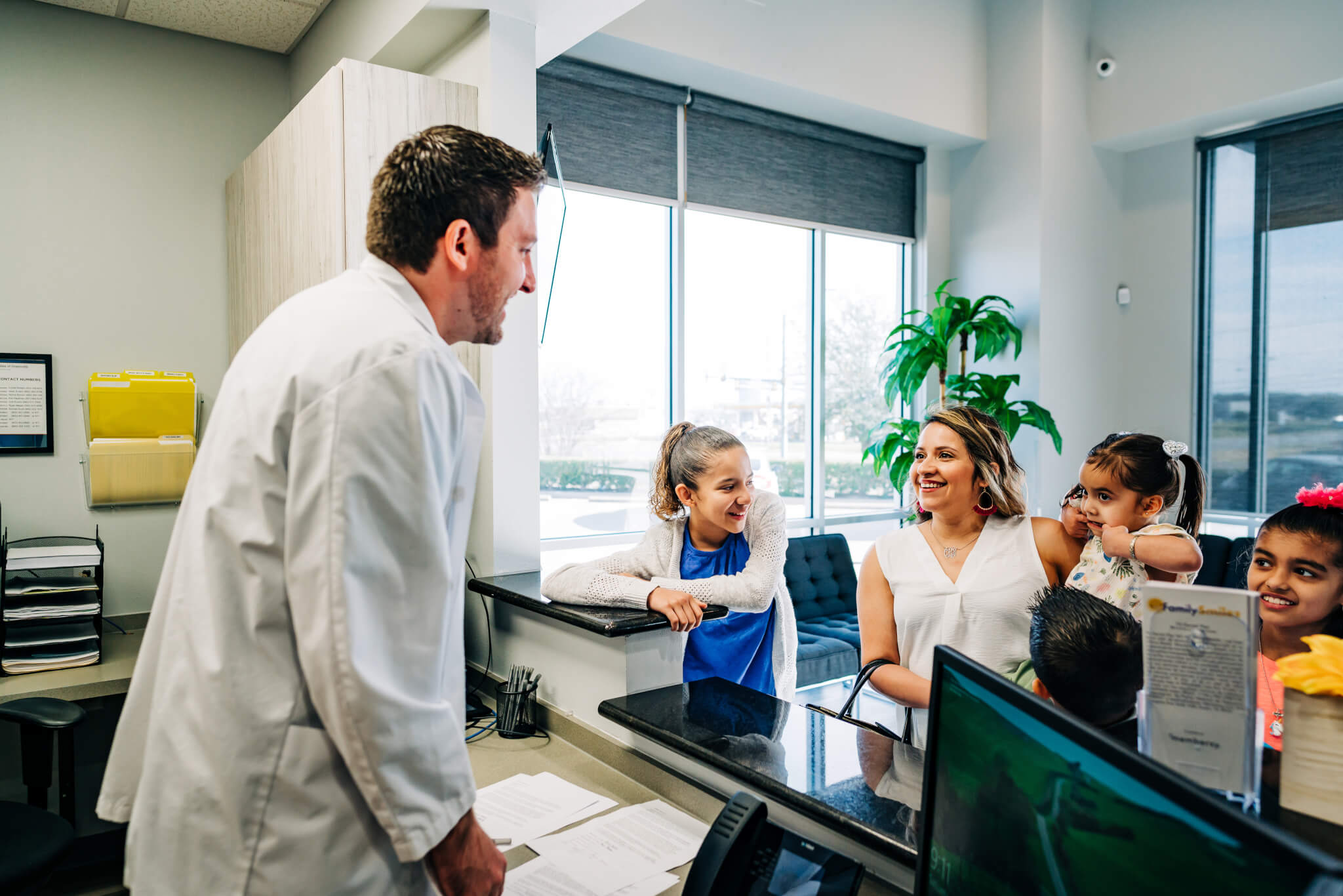 Family Smiles dentist talking to family in waiting room. Read more to discover why Texas is one of the best states for dentists!