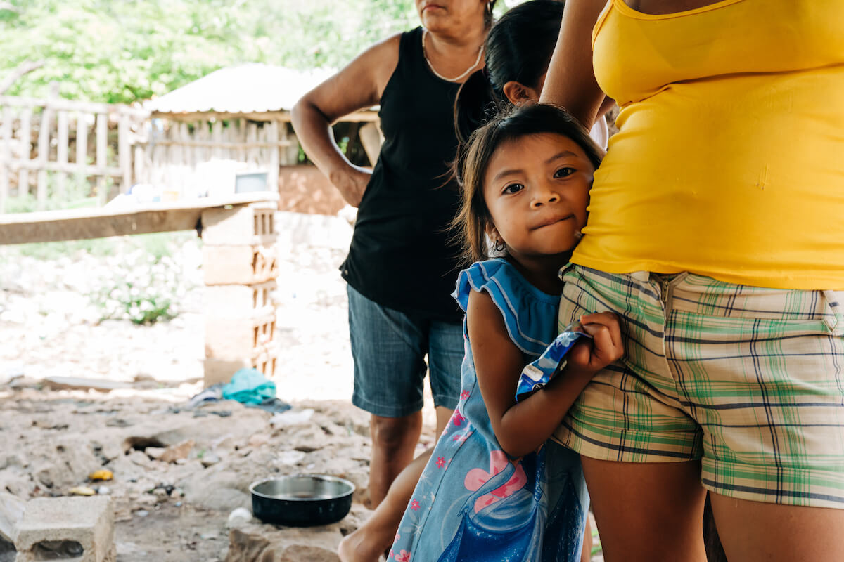 A child holds her mother close while they wait to be treated as part of CDP's dental volunteer program.