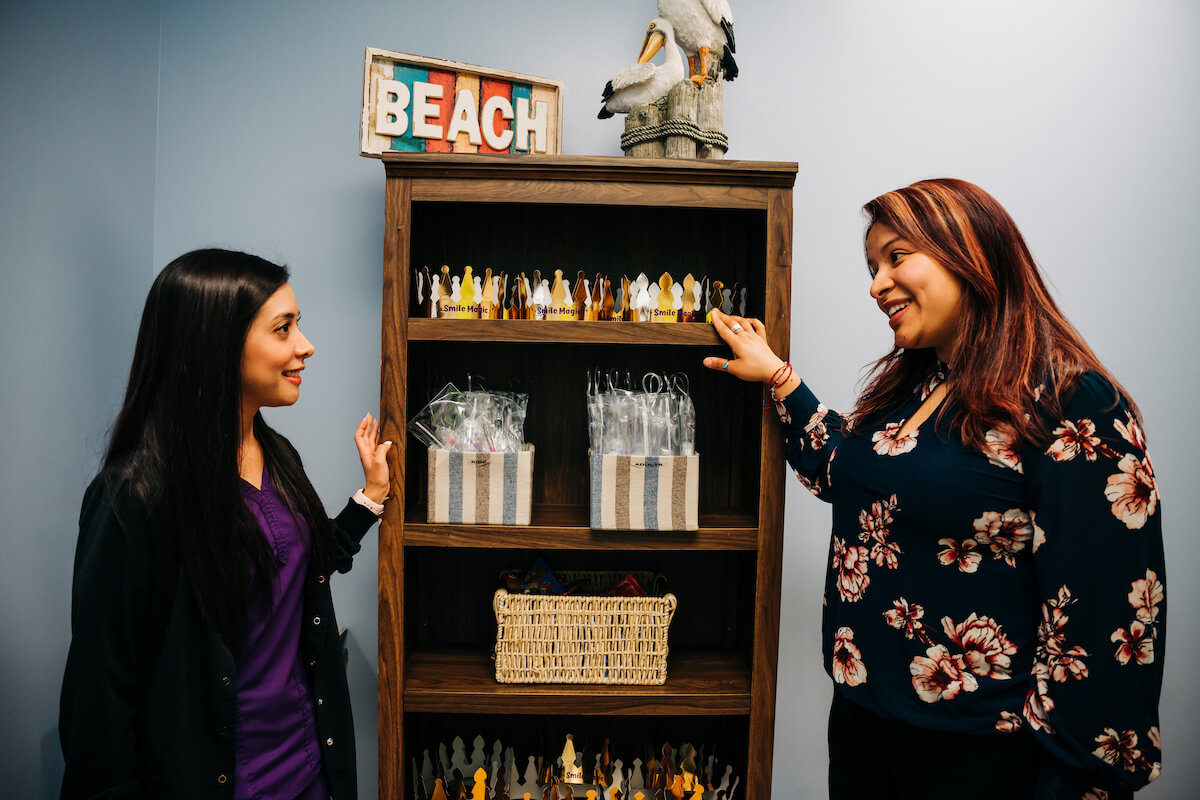 A dentist speaks with a member of her office staff about a patient. It's important to connect with your staff and create a positive culture that everyone can enjoy.