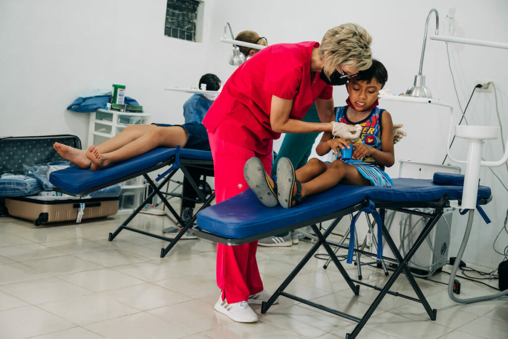 Assistant helps a young male patient with packing gauze in his mouth. Learning to navigate these difficulties with patience and compassion early in your career can prepare you for true greatness. 