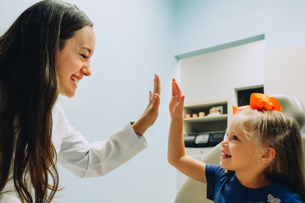 Dentist and child giving each other a high five. 