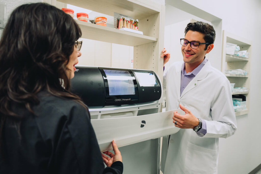 Two dentist looking at a CEREC Primemill. 