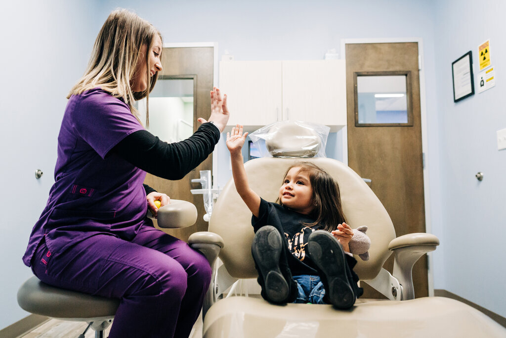 Hygienist giving a young patient a high-five.