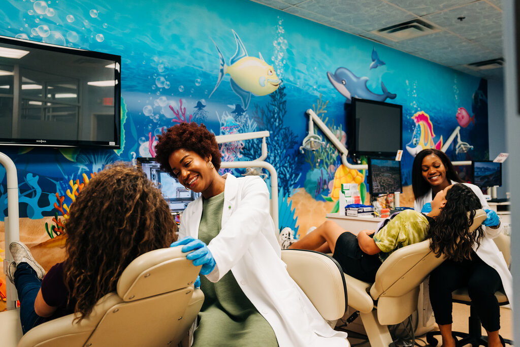 Two dentists with two patients in a dental setting.  A clear outline of how cases are allocated to each doctor can prevent many problems down the road.